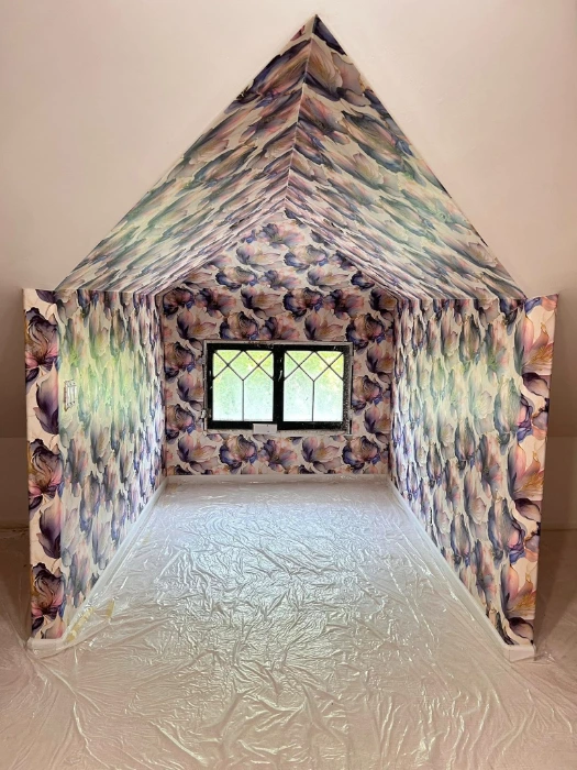 Watercolour floral wallpaper covering the walls and sloped ceiling of a Denver attic room
