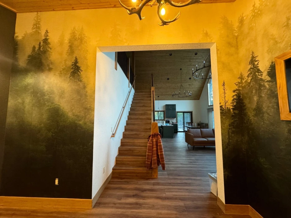 Dark pine forest mural wallpaper framing the entryway of a Denver cabin-style home