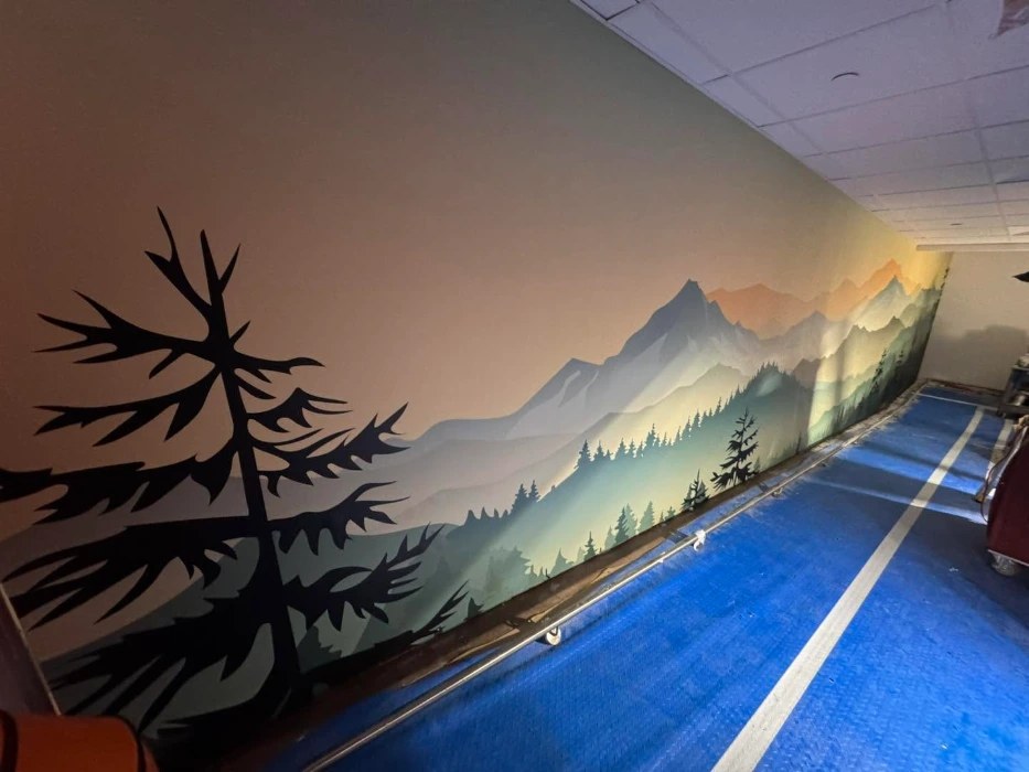 Scenic mountain and pine forest mural wallpaper running the length of a Denver hallway