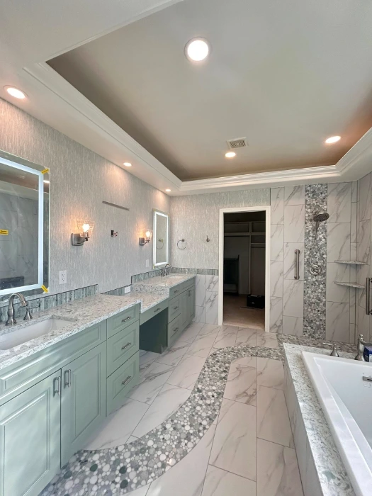 Pale silver textured wallpaper in a luxury Denver master bathroom with a sage double vanity and lit mirrors
